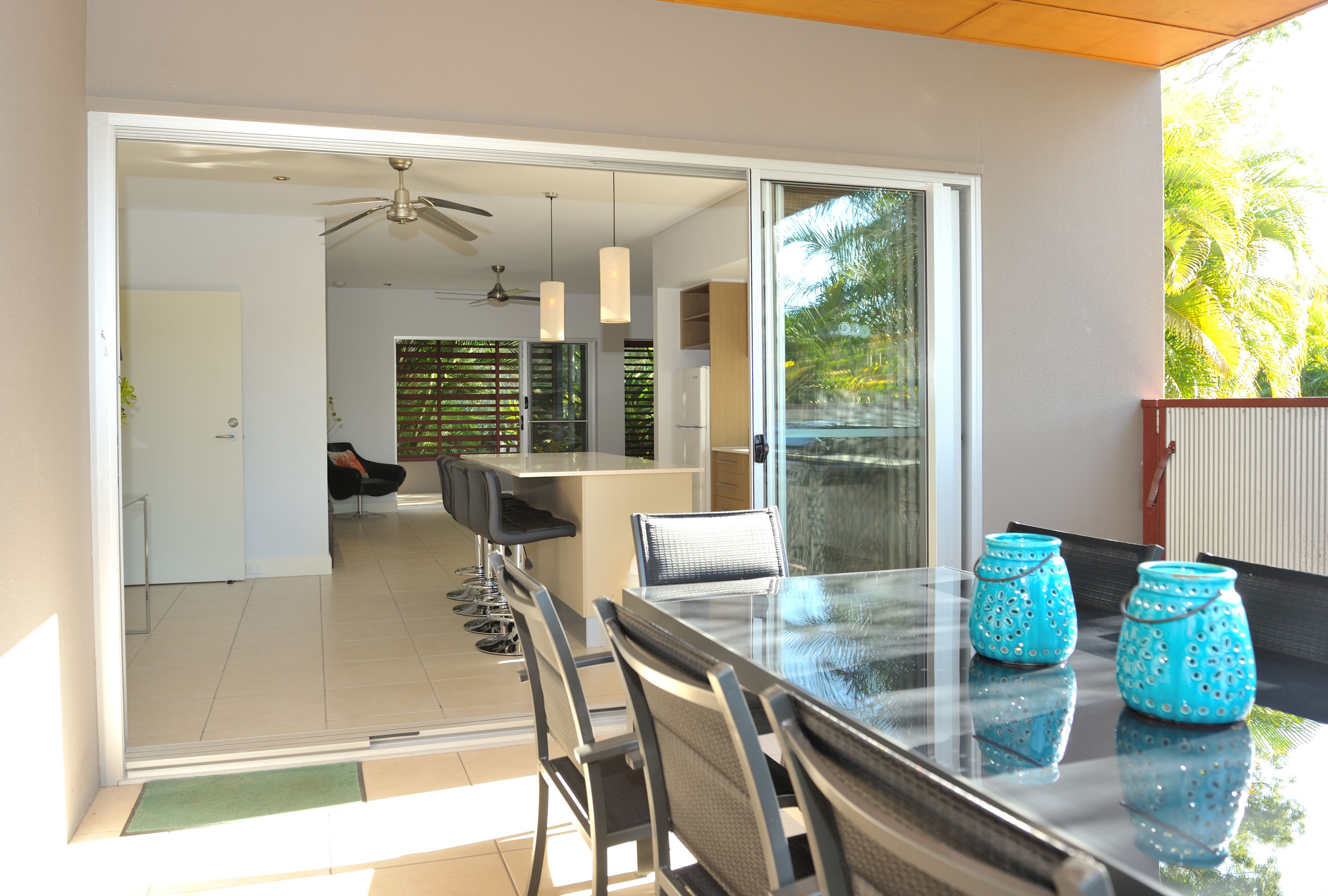 A modern kitchen with a glass door leading to a dining area.