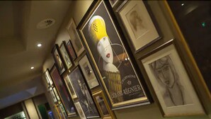A wall with framed pictures and a large poster. - Kings Head (Cirencester)