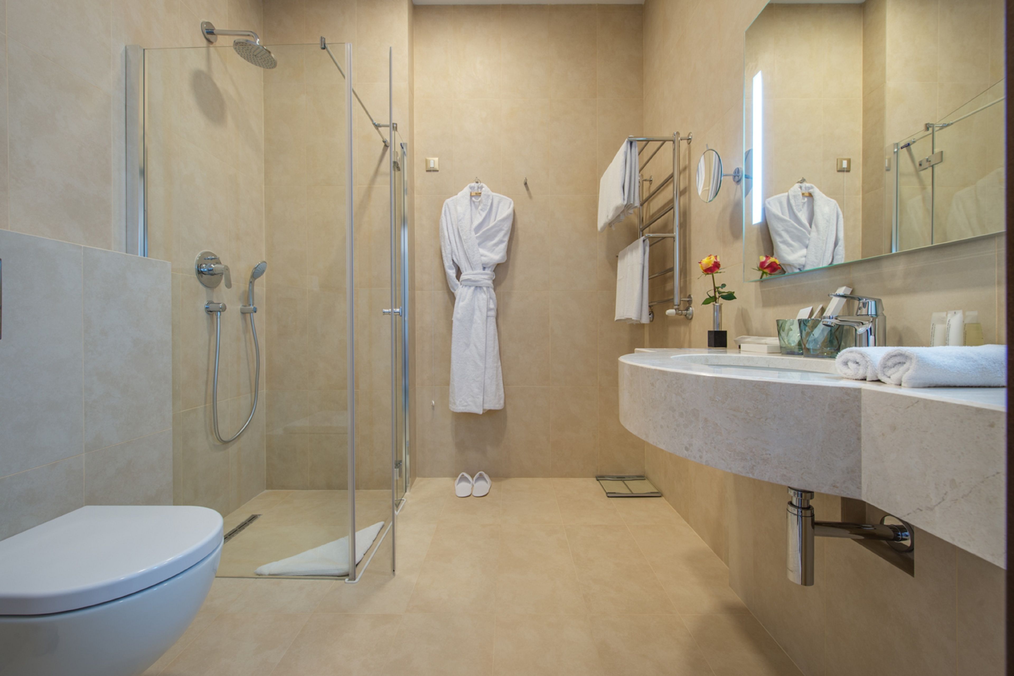 Ein modernes Badezimmer mit Duschkabine aus Glas, Toilette und Waschtisch mit Spiegel.