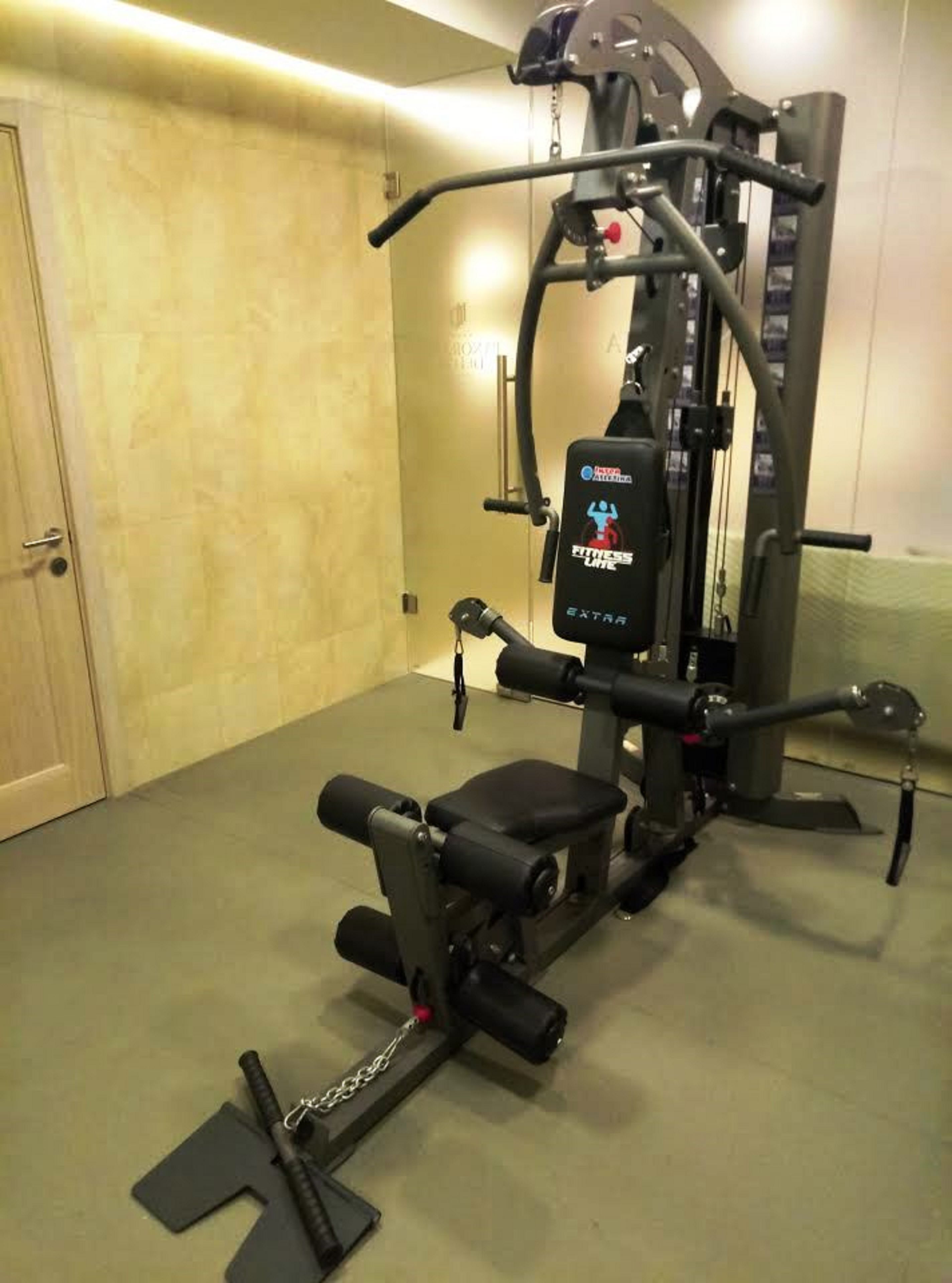 Un gimnasio con banco de pesas, estructura para sentadillas y prensa de banca.