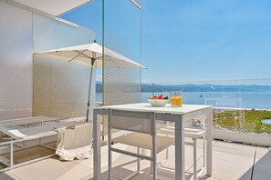 A balcony with a table, chairs, and a view of the sea. - Bevanda Hotel & Restaurant - Unique Adriatic (Opatija)