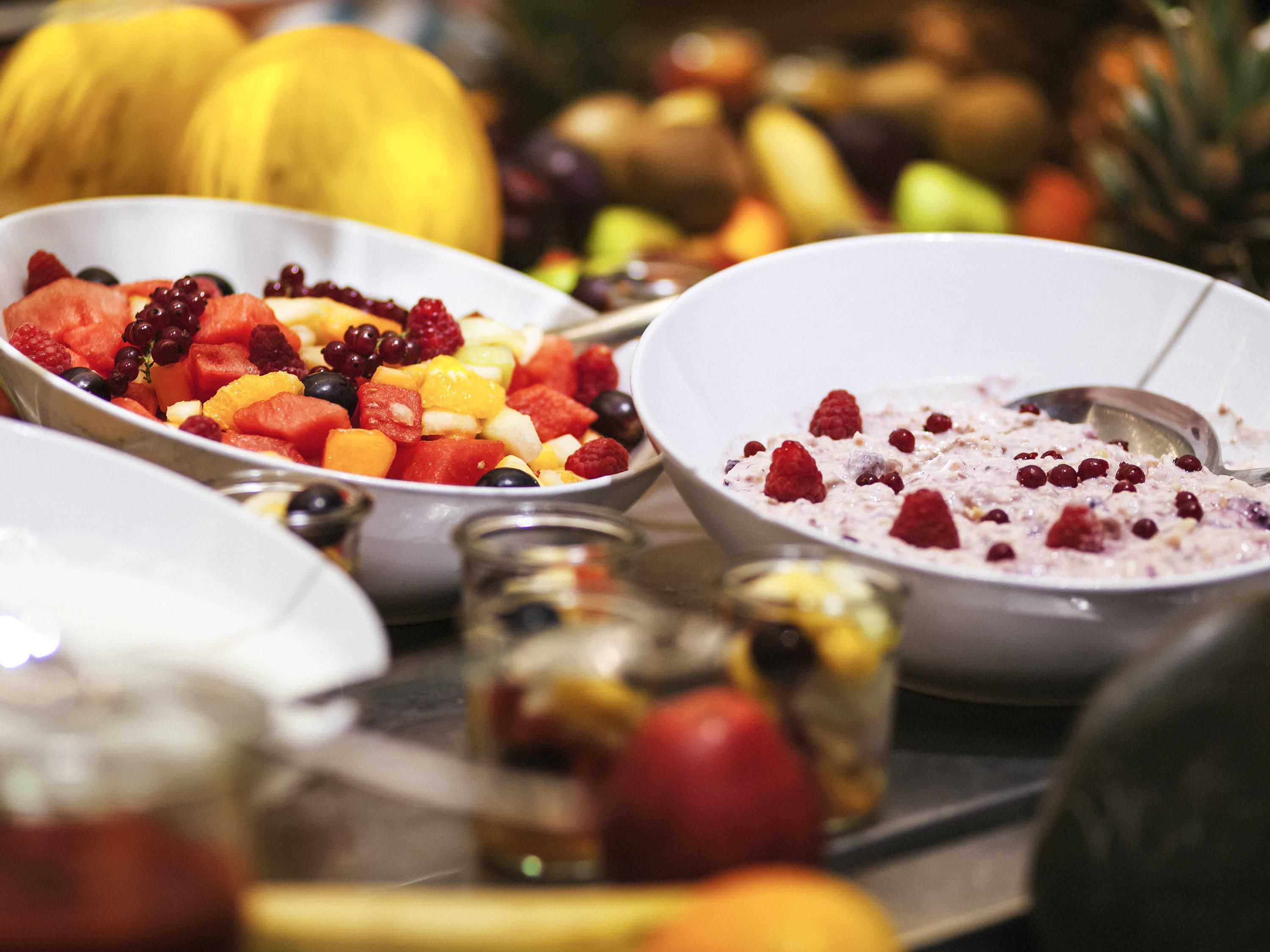 Eine Auswahl an Früchten in Schalen, darunter Wassermelone, Himbeeren und Trauben.