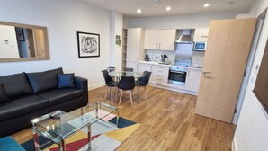 Een modern appartement met een woonkamer, eethoek en keuken.