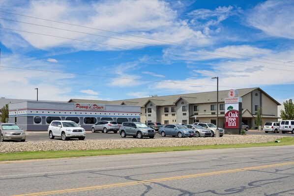 A parking lot with several cars, a Penny's Diner, and an Oak Tree Inn building.