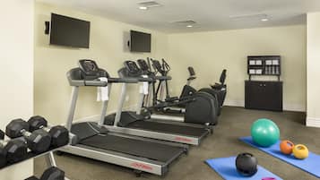A home gym with treadmills, dumbbells, and exercise balls.