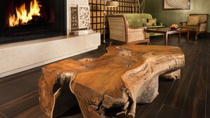 A living room with a fireplace, wooden coffee table, and comfortable seating. - Ayres Hotel Orange (Orange)