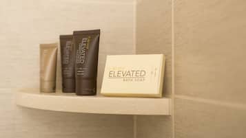 A bathroom shelf with three bottles of bath soap and a box labeled "Elevated Bath Soap".