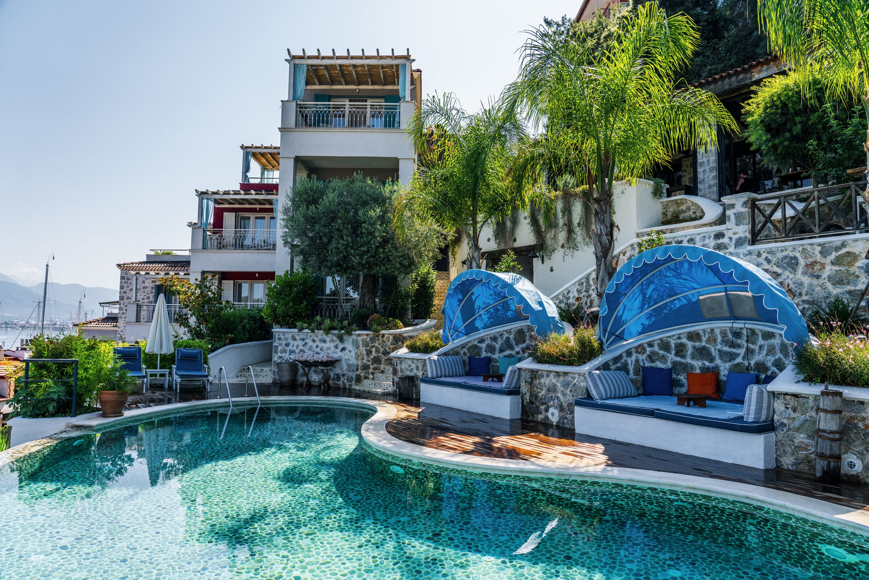A pool area with a stone wall and a blue dome structure.