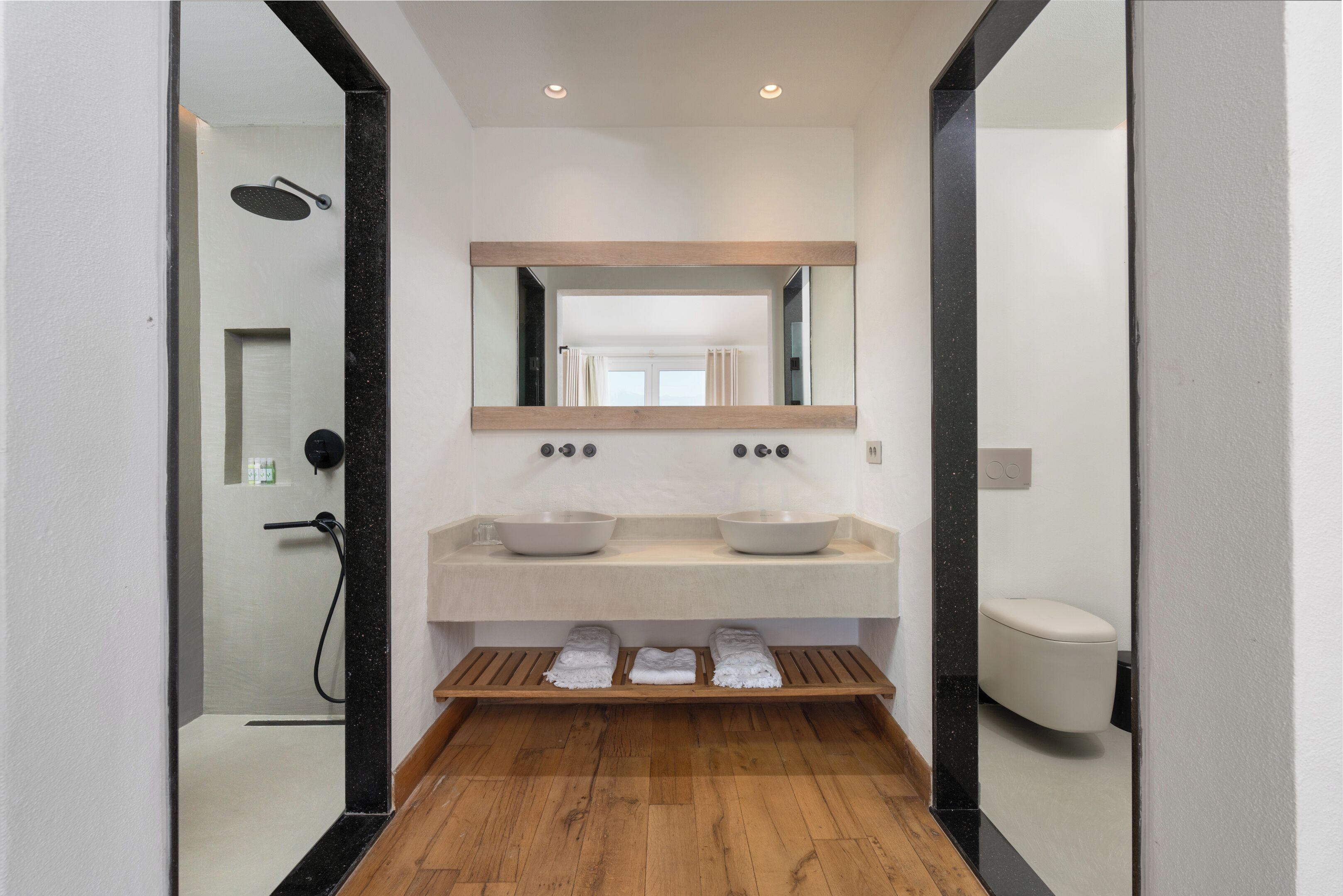Un baño moderno con lavamanos doble, un espejo grande y una ducha.