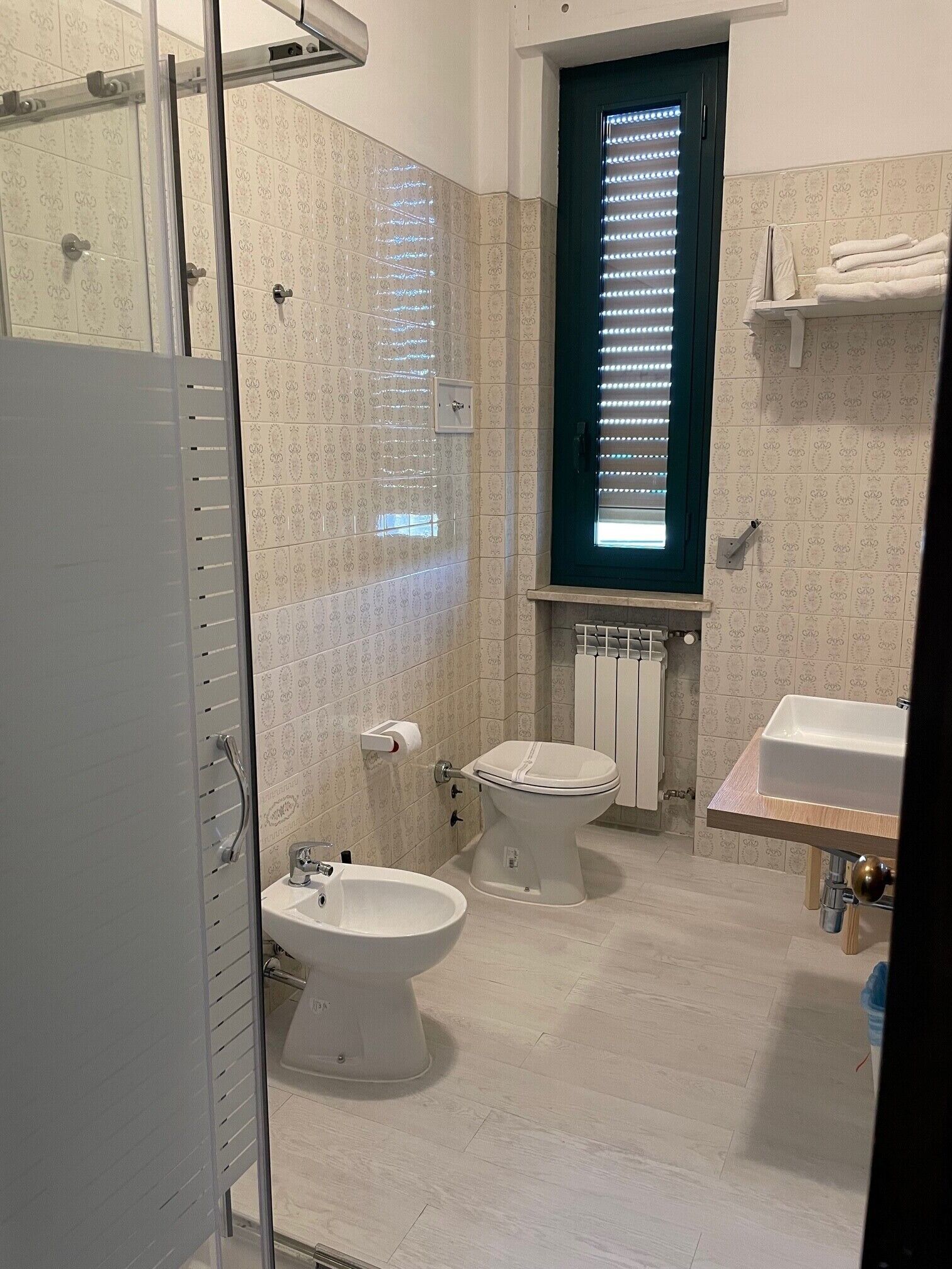 Un baño con ducha, inodoro, bidé y lavamanos.