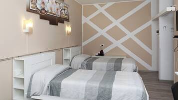 Quarto de hotel com duas camas, prateleira na parede, um quadro e um desenho de parede em padrão cruzado.