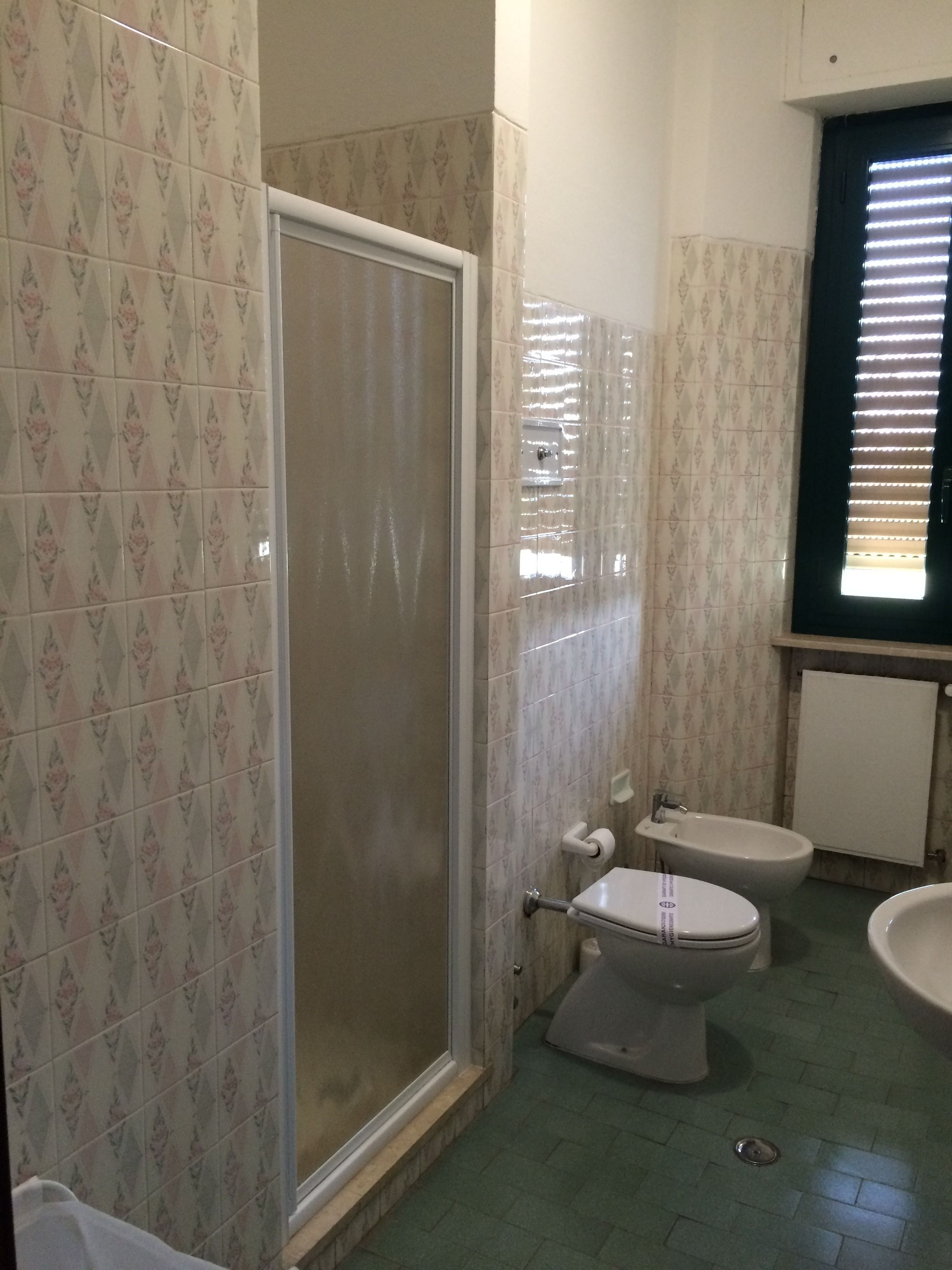 Un baño con ducha, inodoro, bidé y lavamanos.