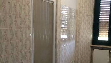 Un baño con ducha, inodoro, bidé y lavamanos.