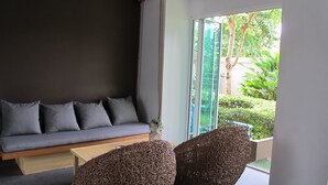 A modern room with a grey sofa, a wooden coffee table, and wicker chairs. - U431 Chaengwattana (Pak Kret)