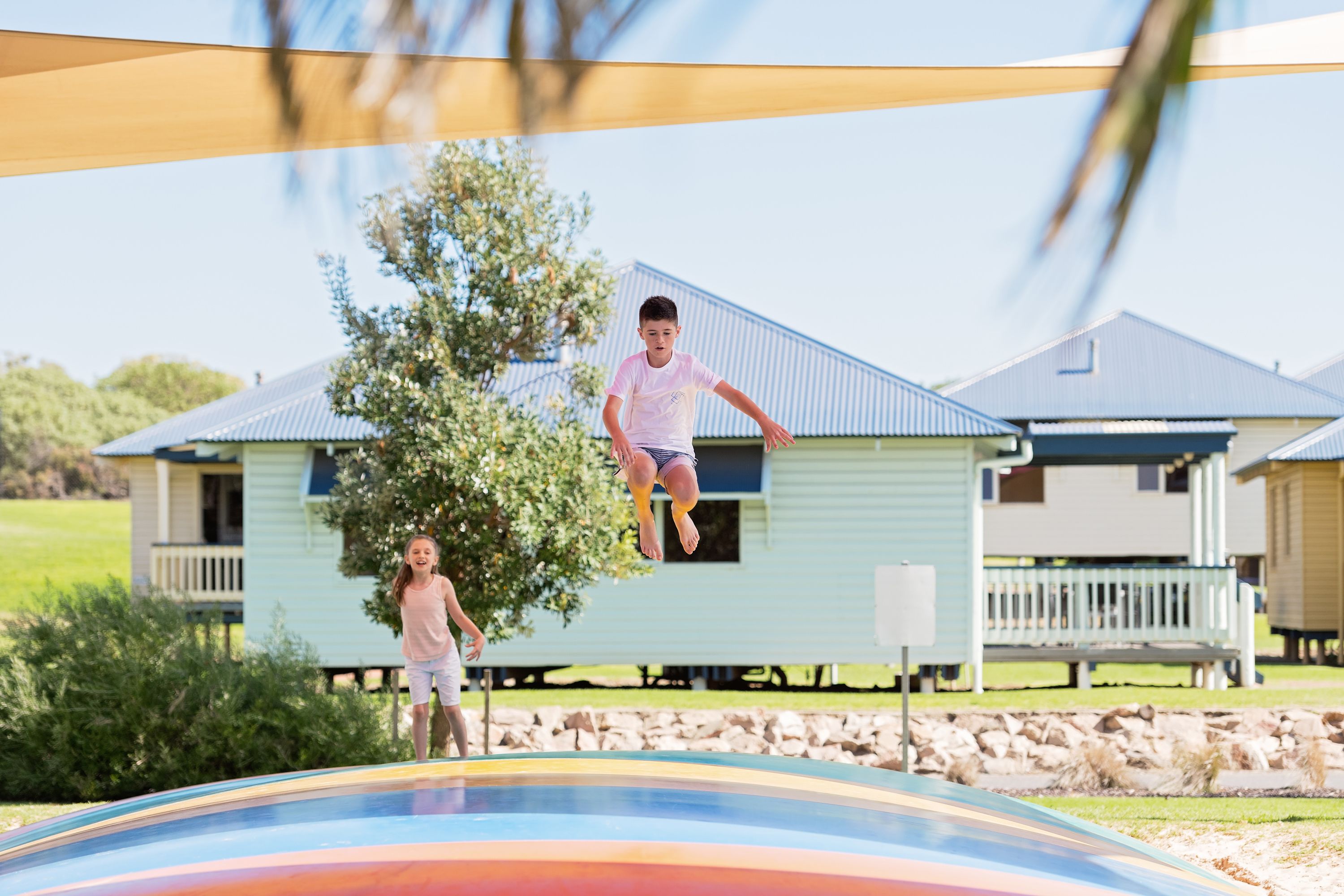 En trampolin i en baghave med et hus i baggrunden.
