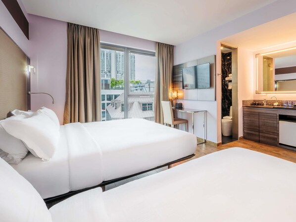 A hotel room with two beds, a desk, a TV, and a bathroom. - Mercure Singapore Tyrwhitt (Singapore)