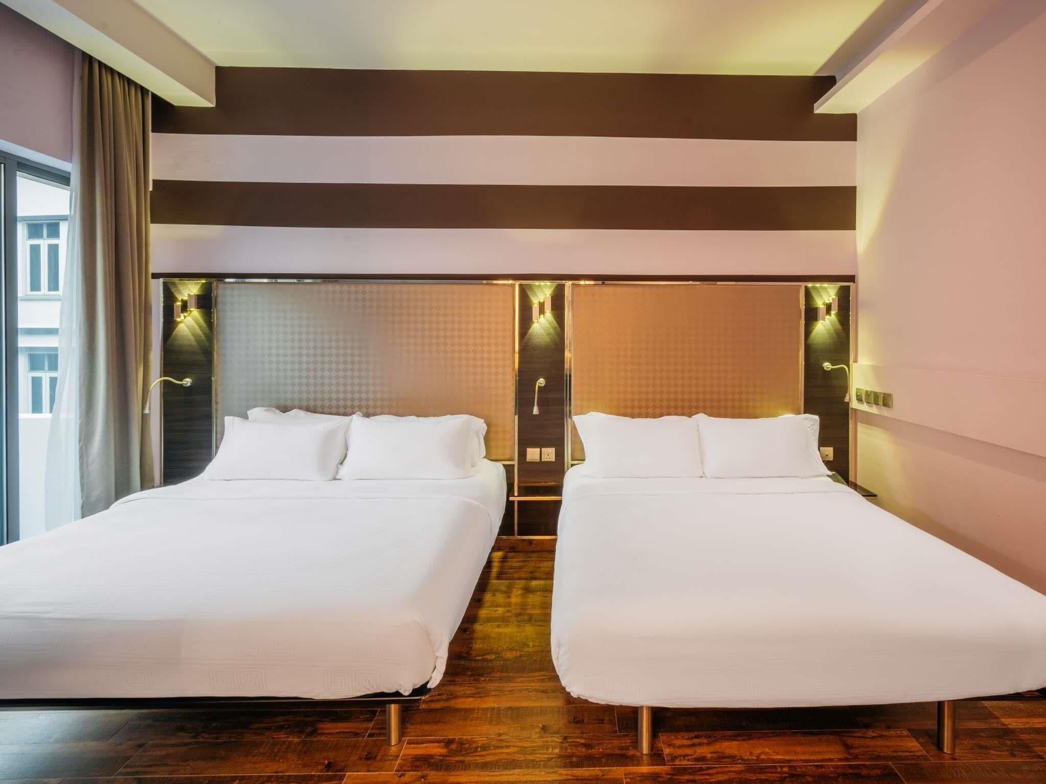 Een hotelkamer met twee bedden, een groot raam en een modern design.