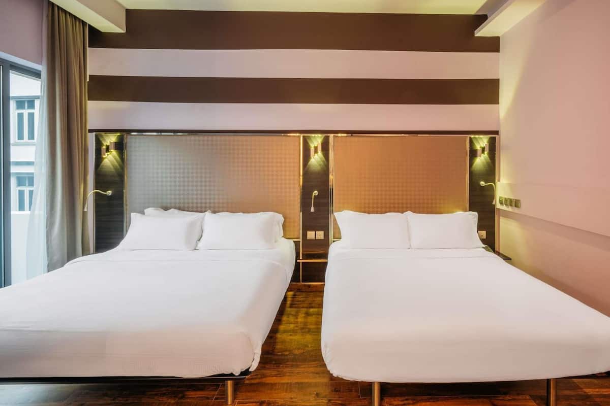A hotel room with two beds, a large window, and a modern design.