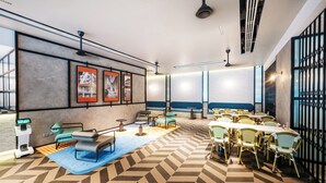 Un moderno vestíbulo de hotel con piso de diseño geométrico, zonas de estar y cuadros enmarcados en las paredes.