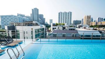 A rooftop pool with a cityscape view, surrounded by modern buildings.