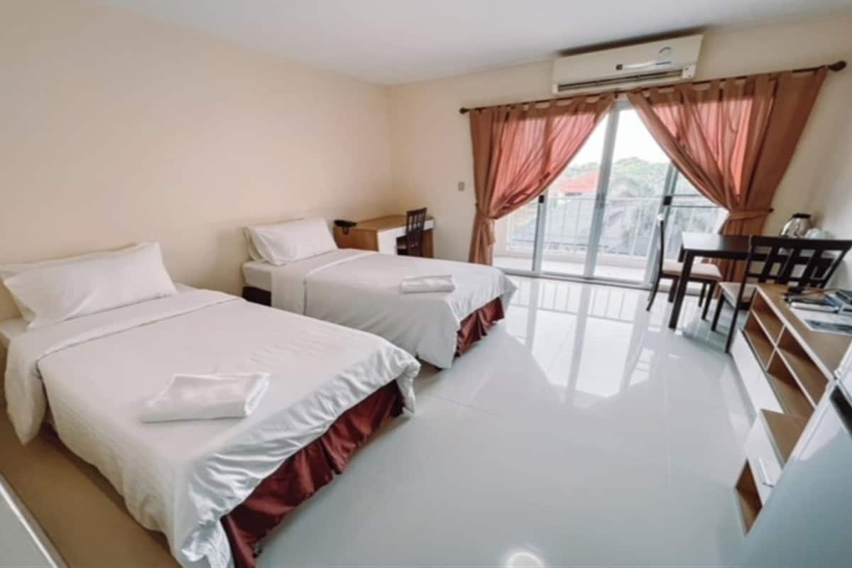 Una habitación de hotel con dos camas, un escritorio y una silla.