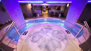 A hot tub with a 50 cm depth label, surrounded by a pool with a circular design and metal railings.