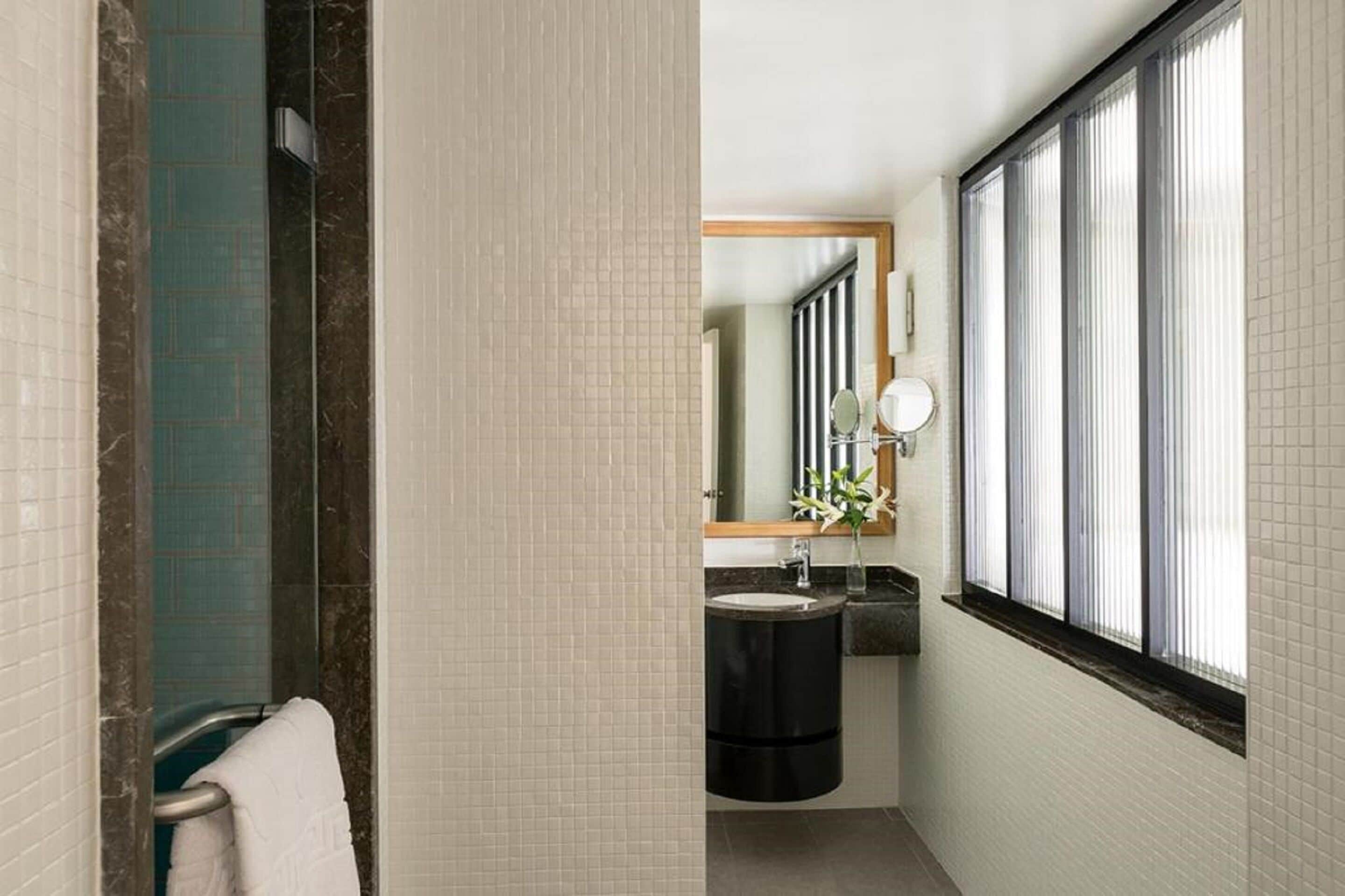 deluxe room | bathroom | shower, rainfall showerhead, designer toiletries, hair dryer