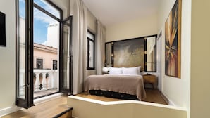 A bedroom with a bed, a nightstand, a painting, and a view through an open window.