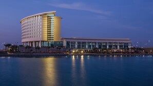 A modern hotel with a curved facade, large windows, and a waterfront view. - Bay La Sun Hotel & Marina (Rabigh)