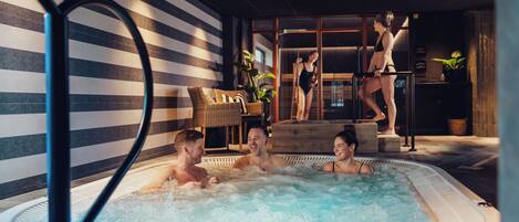 A hot tub area with a striped wall and a glass partition.