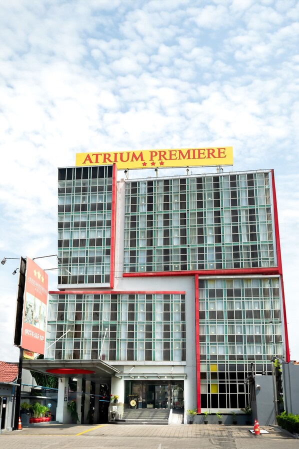 Un bâtiment moderne avec une enseigne indiquant « ATRIUM PREMIERE » et une grande façade vitrée.