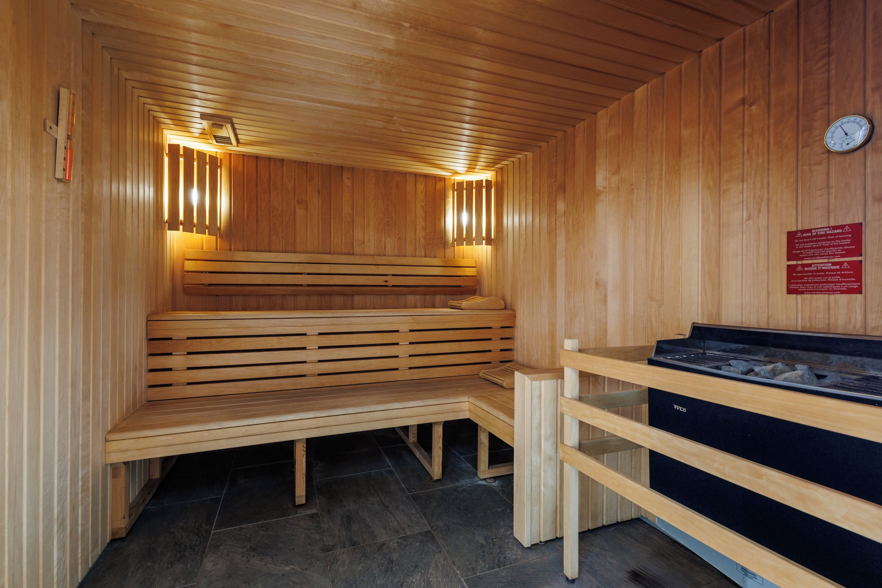 A wooden sauna with benches and a sauna table.