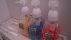 A bathroom with three bottles of body soap, one conditioner, and a set of toothbrushes on a tray. - Hotel Fosse Himeji (Himeji)