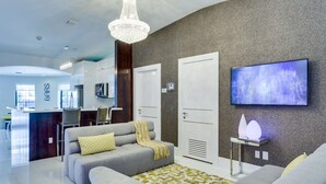 A modern living room with a grey sofa, a patterned rug, and a chandelier. - Bars B&B South Beach Miami Boutique Hotel (Miami Beach)