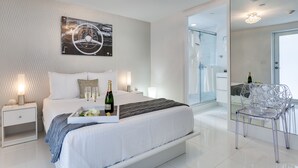 A modern bedroom with a large bed, a glass shower, and a clear chair. - Bars B&B South Beach Miami Boutique Hotel (Miami Beach)