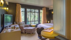 A hotel room with a bed, a desk, a chair, a TV, and a bathroom with a sink and mirror. - West Wood Hotel (Nairobi)