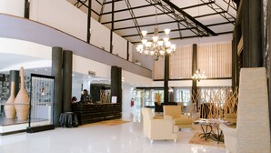 A spacious lobby with a reception desk, seating area, and decorative vases. - West Wood Hotel (Nairobi)