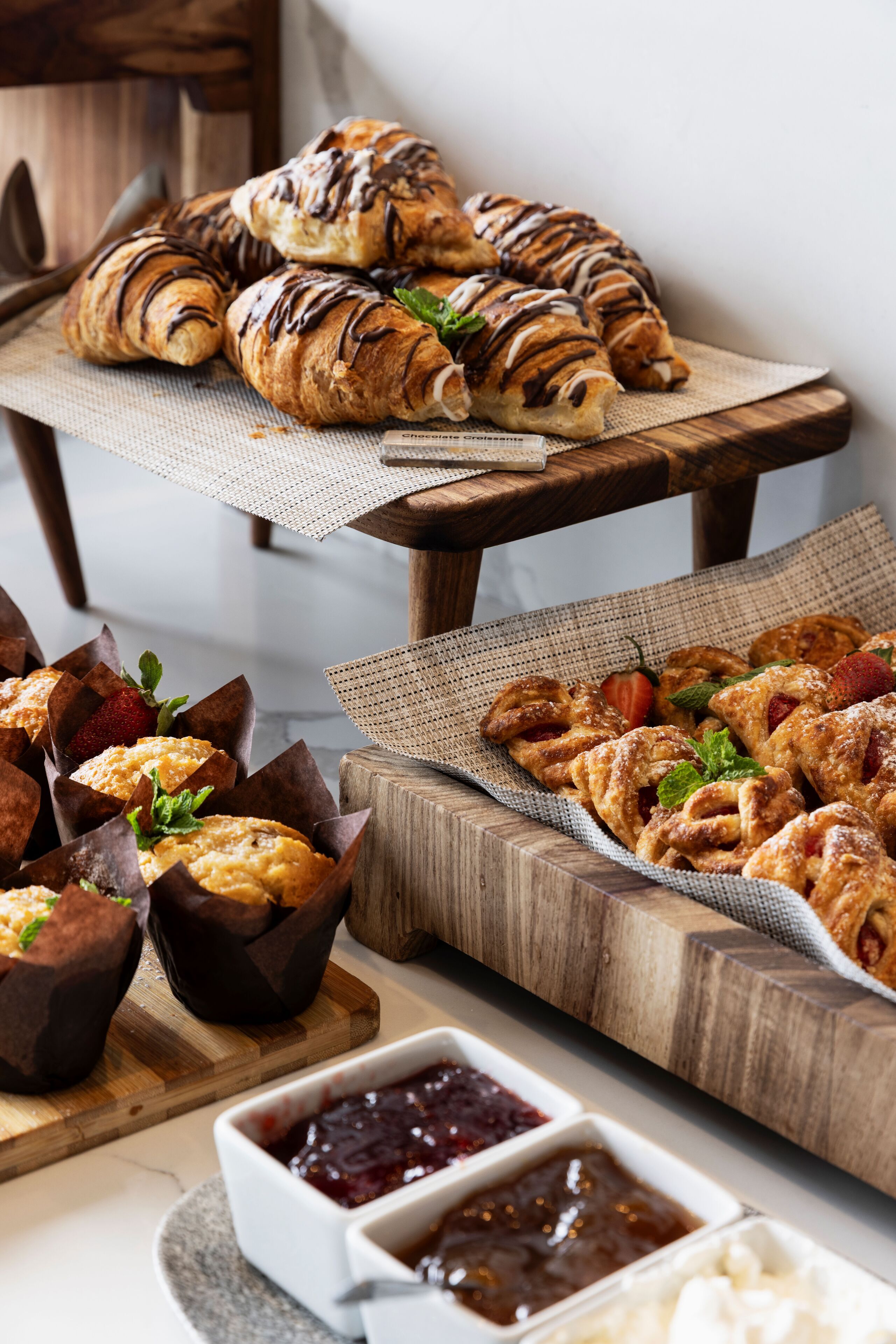 Une table en bois avec des pâtisseries et des confitures.