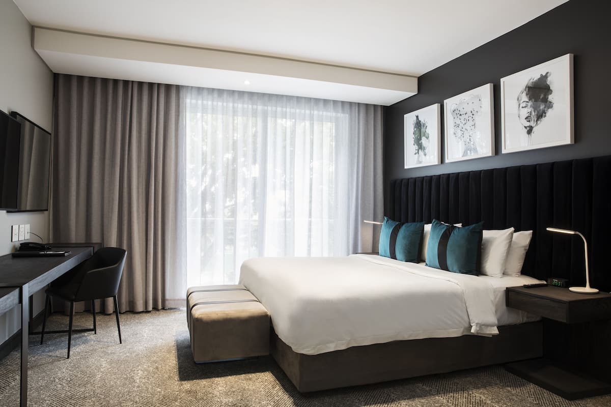Een moderne hotelkamer met een groot bed, een bureau en een televisie.