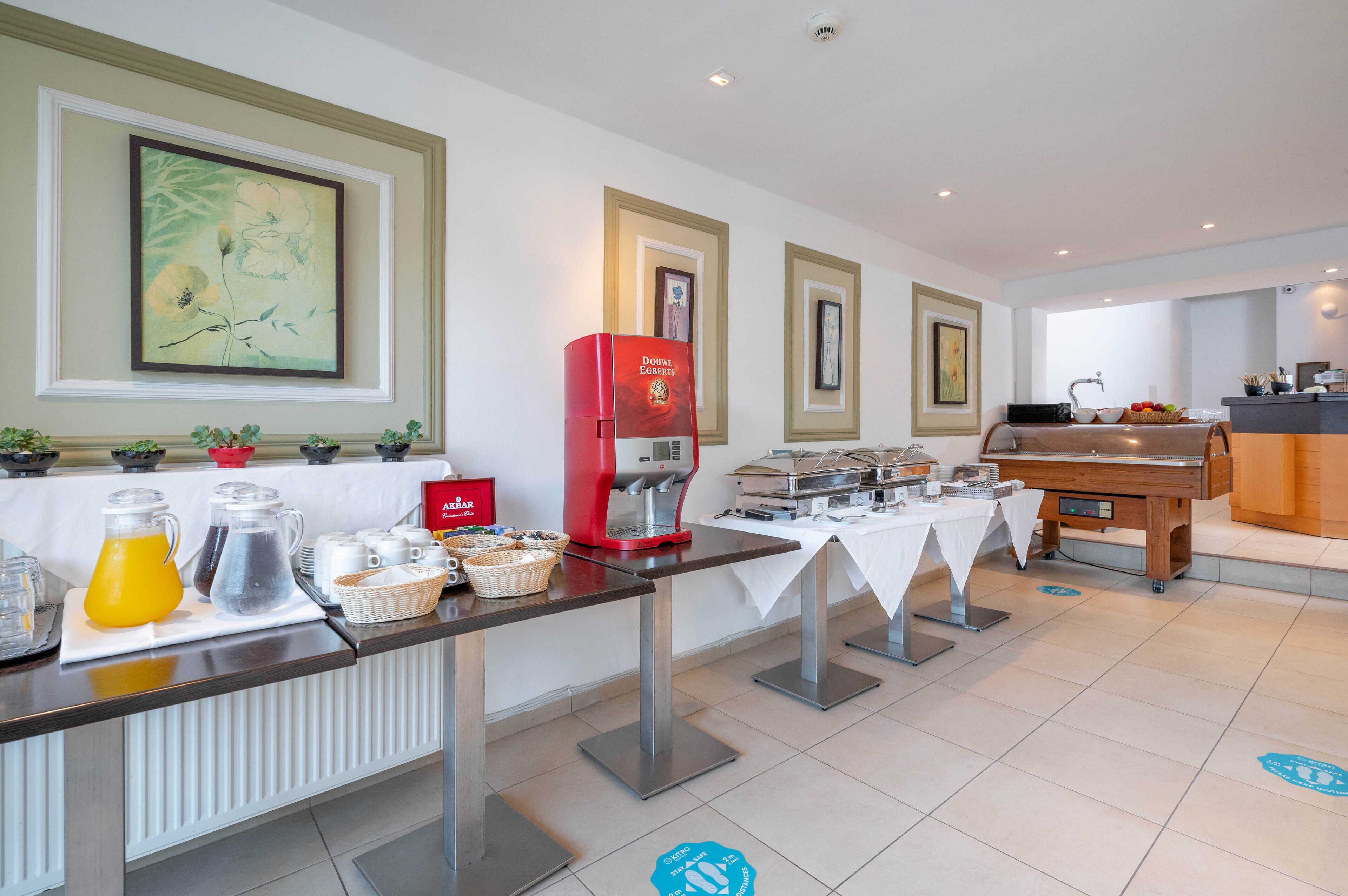Un buffet de petit-déjeuner comprenant une machine à café, des jus de fruits et divers aliments.
