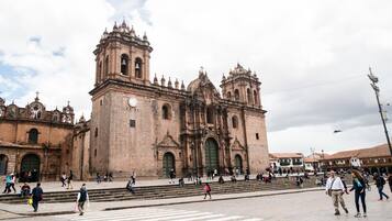 Una iglesia histórica con una imponente torre campanario y grandes puertas verdes.