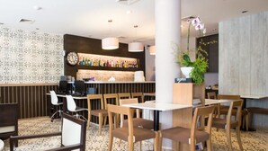 Ein Restaurantinnenraum mit Holzbänken, einer Bar und einem gemusterten Boden.