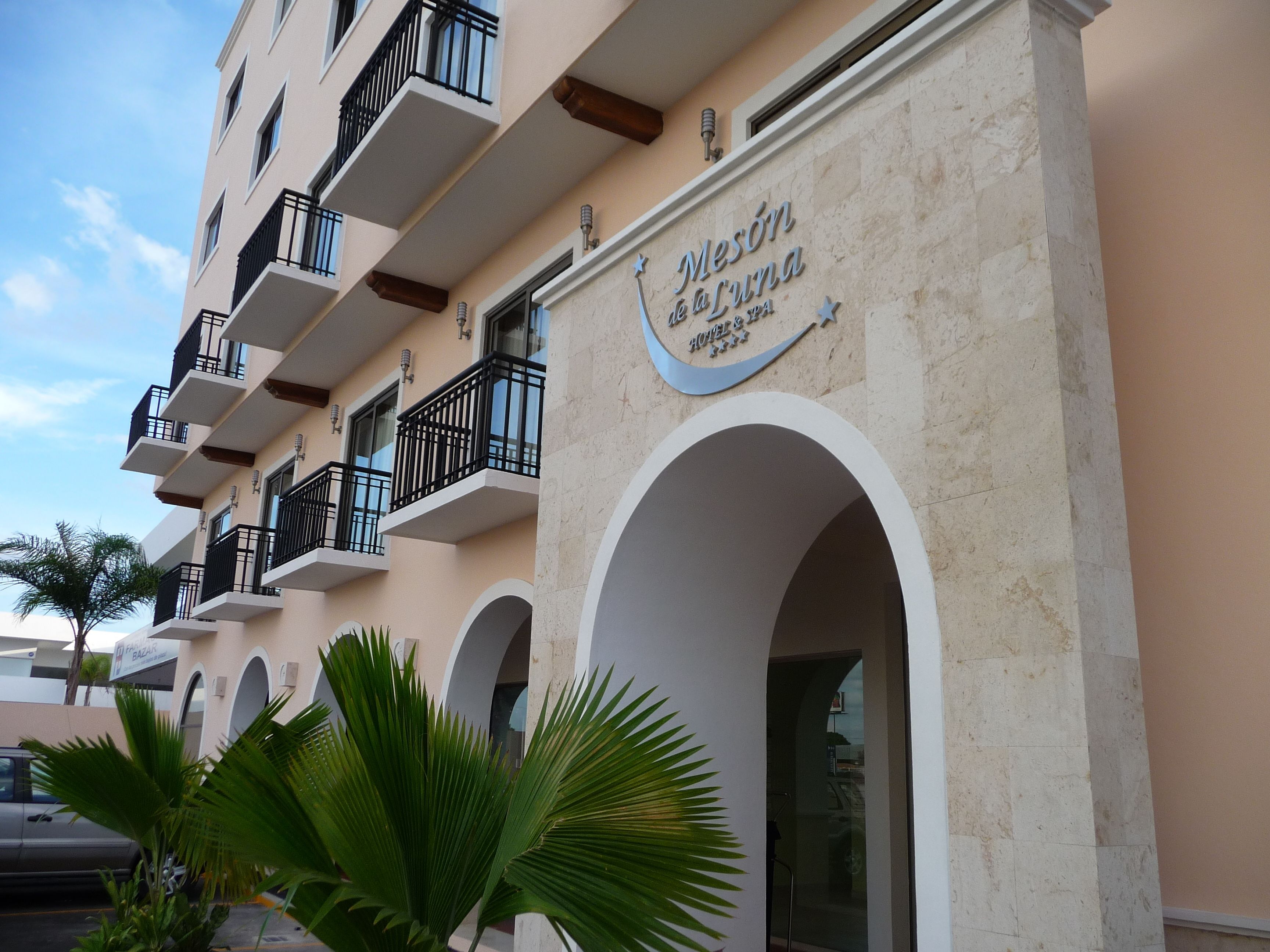 A hotel facade with balconies, arched doorways, and a sign indicating it is a hotel and restaurant.