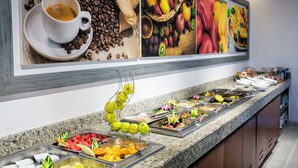 Un buffet proposant une variété de plats, une tasse de café et une présentation de fruits.