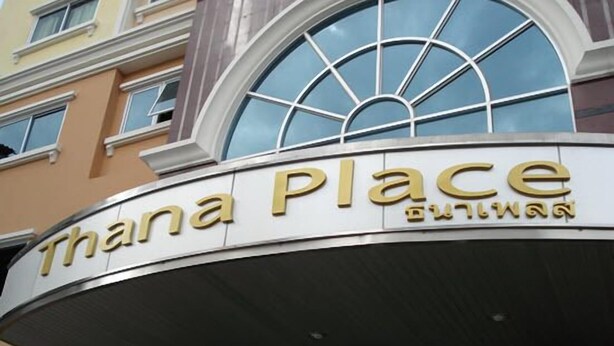 A hotel entrance with a curved sign reading "Thana Place" and a large arched window above it. - Thanaplace Jaran 34 (Bangkok)