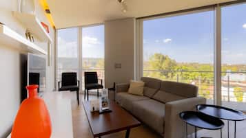 Deluxe Suite | Living area | 39-inch flat-screen TV with cable channels, TV