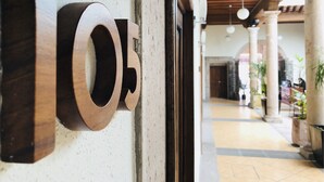 Un pasillo con un letrero numérico grande y moderno, vigas de madera y luces colgantes.
