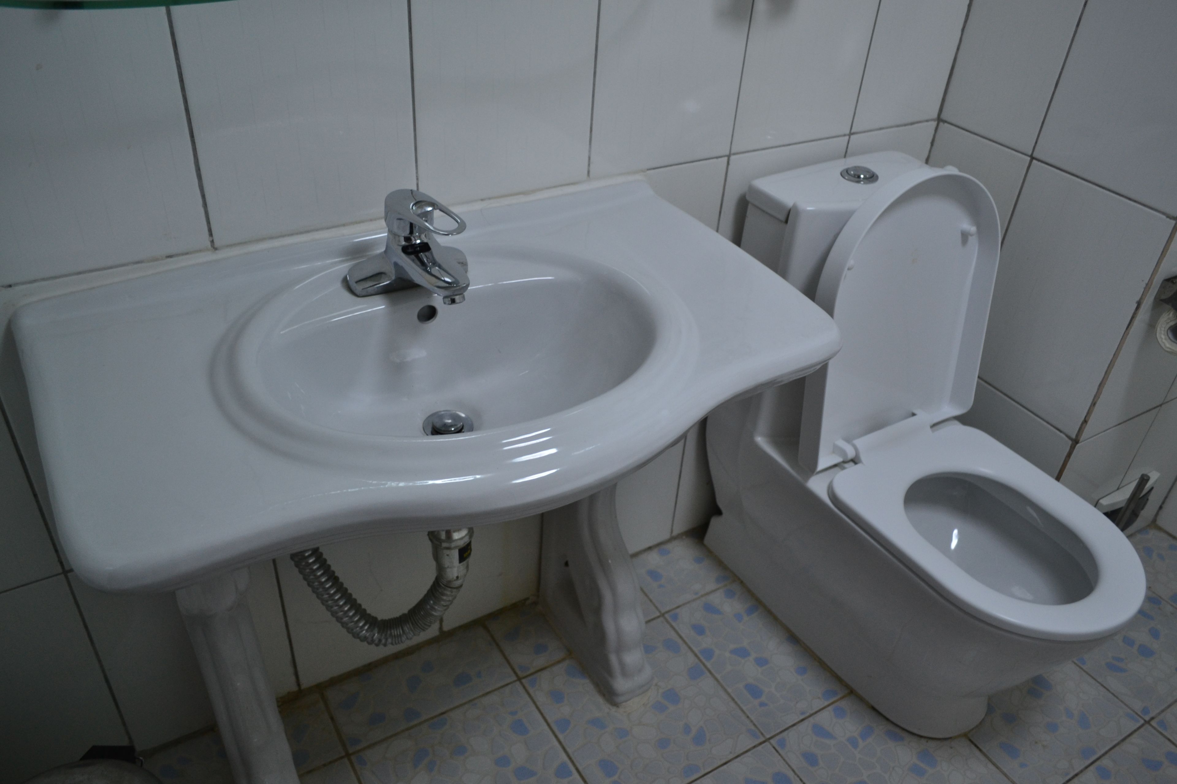 A bathroom with a white sink and toilet.