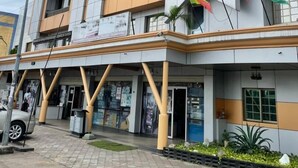 A multi-story building with a modern architectural design, featuring a mix of glass and beige panels. - DK Hotel (Bonaberi)