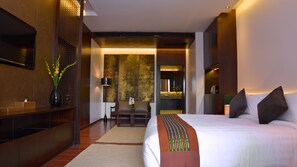 A modern hotel room with a large bed, a desk, and a seating area. - Emerald Palace Hotel (Naypyidaw)